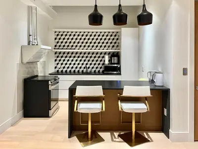 a kitchen with a black counter and stools at Cozy&Private Suite in Vancouver in Vancouver