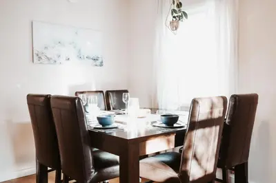 a dining room table with leather chairs and a wooden table at Stay & Play - Central Family Friendly in Calgary