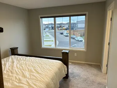 a bedroom with a bed and a large window at Bedroom SW Edmonton HWY 2 near YEG in Edmonton