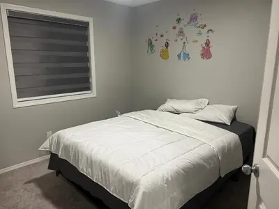 a bedroom with a bed and a window with a picture on the wall at Bedroom SW Edmonton HWY 2 near YEG in Edmonton