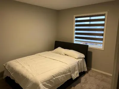 a bedroom with a bed and a window at Bedroom SW Edmonton HWY 2 near YEG in Edmonton