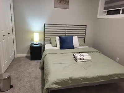 a bedroom with a bed with a pillow on it at Home away from Home in Calgary