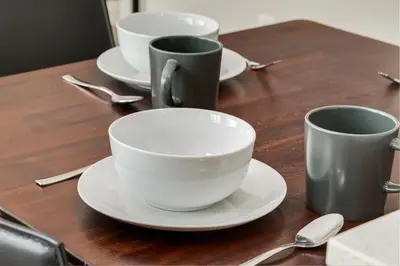 three cups and saucers on a wooden table at Inner City Apartment, Pet Friendly, Free Underground Parking in Calgary