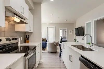 a kitchen with white counter tops and a sink at Inner City Apartment, Pet Friendly, Free Underground Parking in Calgary