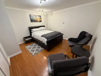 a bedroom with a bed and a chair in it at Place near the Coquitlam River Park in Coquitlam