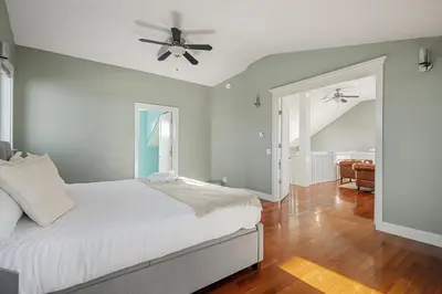 a white bedroom with a bed and a ceiling fan at Home Alone Retreat in Calgary