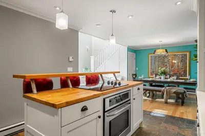 a kitchen with white cabinets and a table in the background at Home Alone Retreat in Calgary