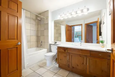 a bathroom with a sink and a tub and a toilet at Northstar Whistler Village Resort in Whistler