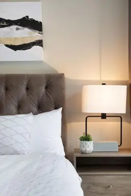 a bed with a lamp on a night stand next to it at Northstar Whistler Village Resort in Whistler