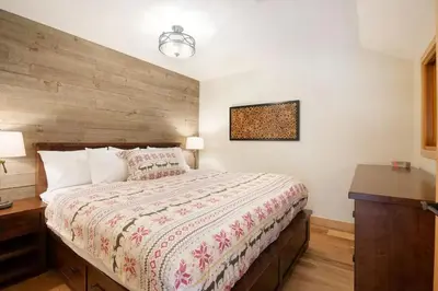 a bedroom with a large bed with a wooden headboard at Large Village loft with Private Hot Tub and Private Sauna in Whistler
