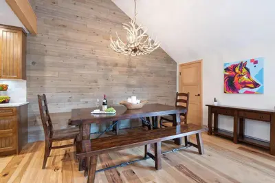a dining room with a wooden table and a chandelier at Large Village loft with Private Hot Tub and Private Sauna in Whistler