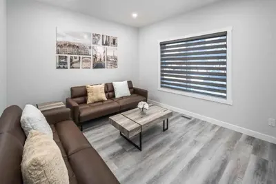 a living room with a couch and a table at Near Downtown, Large 3BR! FREE Banff Pass, Netflix, Parking! in Calgary