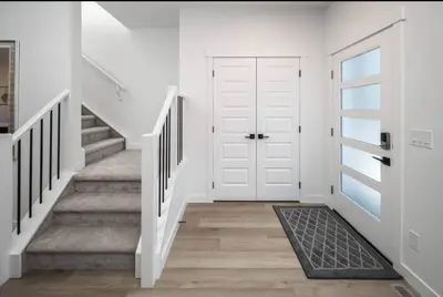 a hallway with a white door and stairs at Near Downtown, Large 3BR! FREE Banff Pass in Calgary