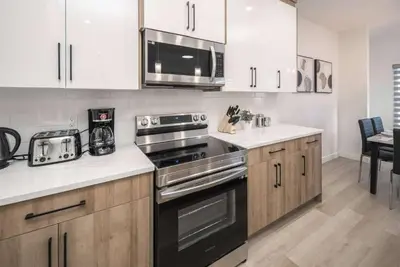 a kitchen with a stove and a microwave at Near Downtown, Large 3BR! FREE Banff Pass in Calgary