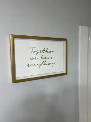 a framed picture on a wall with the words together we have everything at Garden Suite in Colwood in Victoria