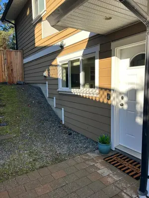 a house with a white door and a porch at Garden Suite in Colwood in Victoria