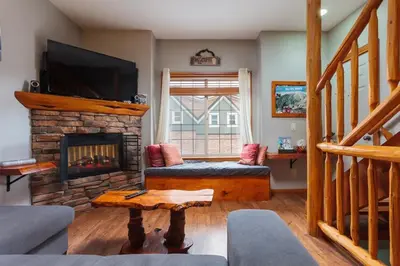 a living room with a fireplace and a tv at BigWhite Ski In-Out Chalet w Priv HotTub & Garage in Big White