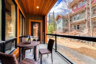 a balcony with a table and chairs on a house at C111 Canmore World Class Solara Resort - Hot tub, Pool, Gym, AirCon, Free Parking & Netflix in Canmore