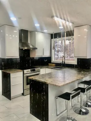 a kitchen with white cabinets and a marble counter top at Modern and luxury 3500 sq feet house jetted tub over 10000 sq feet lot in Edmonton
