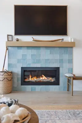 a living room with a fireplace with a tv above it at Saratoga Beachfront Villa in Oyster Bay