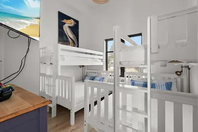 a bedroom with two bunk beds and a desk at Saratoga Beachfront Villa in Oyster Bay
