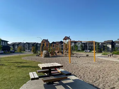 a park with benches and a playground with houses at Charming Oasis Tranquil Suite 8 min Airport, AC in Calgary