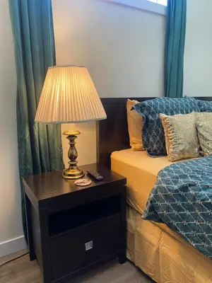 a bedroom with a bed and a lamp on a night stand at Charming Oasis Tranquil Suite 8 min Airport, AC in Calgary