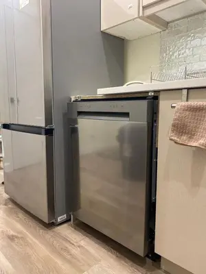 a kitchen with a stove and a refrigerator at Charming Oasis Tranquil Suite 8 min Airport, AC in Calgary