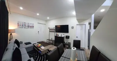 a living room with a couch and a tv at Charming Oasis Tranquil Suite 8 min Airport, AC in Calgary