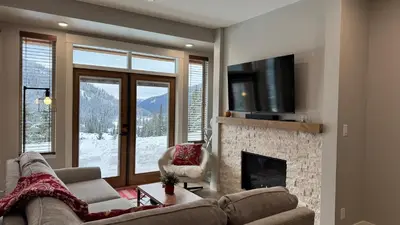 a living room with a couch and a fireplace at Powder Heights #25 home in Sun Peaks
