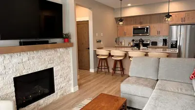 a living room with a couch and a fireplace at Powder Heights #25 home in Sun Peaks