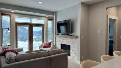 a living room with a couch and a fireplace at Powder Heights #25 home in Sun Peaks