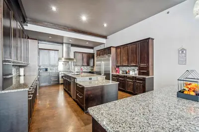 a large kitchen with wooden cabinets and granite counter tops at Luxurious Modern 11-Bed Home Private 136 Acres in Spruce Grove