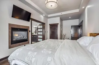 a bedroom with a large bed with a tv on the wall at Luxurious Modern 11-Bed Home Private 136 Acres in Spruce Grove