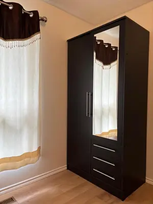 a black cabinet with a mirror in a room at Kevin Calgary Beddington Home in Calgary