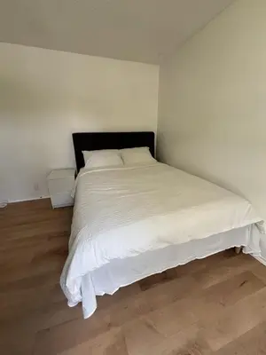 a bedroom with a large bed with white sheets at Kevin Calgary Beddington Home in Calgary
