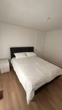 a bedroom with a large white bed in a room at Kevin Calgary Beddington Home in Calgary