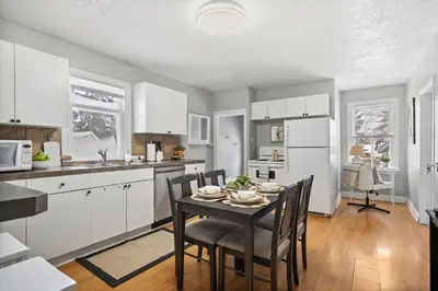 a kitchen with white cabinets and a table with chairs at Sylvan Lake Nook Family-Friendly and Close to Beach in Sylvan Lake