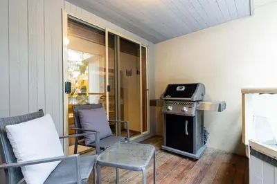 a living room with a stove and two chairs at 2BR in Gleneagle, Heated Flooring, Wood Burning Fireplace, Shuttle to Gondola in Whistler