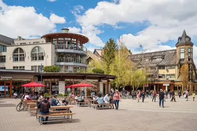 a group of people sitting on benches in a city street at 2BR in Gleneagle, Heated Flooring, Wood Burning Fireplace, Shuttle to Gondola in Whistler