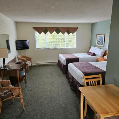 a hotel room with two beds and a table at Pacific Rim Motel in Ucluelet