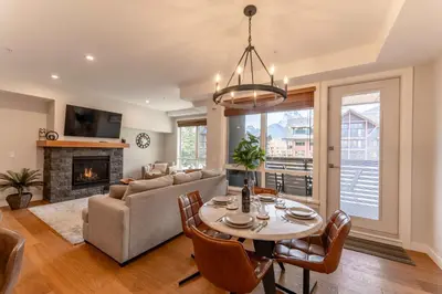 a living room with a table and a couch at Modern Mountain Oasis Top floor 2 level 2bd in Canmore