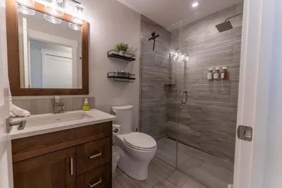 a bathroom with a toilet and a sink and a shower at Modern Mountain Oasis Top floor 2 level 2bd in Canmore