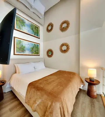 a bedroom with a bed and two mirrors on the wall at Two-Story Loft with a High-rises view and Rooftop Deck in Vancouver