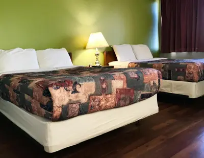 two beds sitting next to each other in a room at Home Away Inn in Drayton Valley