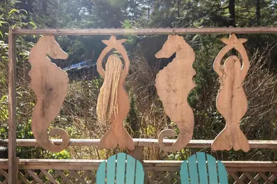 a wooden sign with horses on a fence at Salal Forest - 2 bedroom cabin in the forest in Tofino