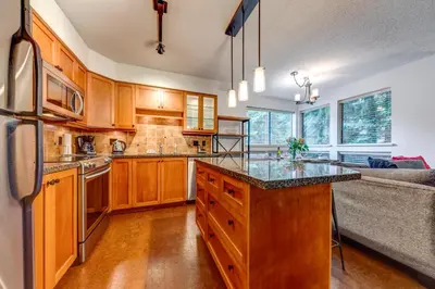 a kitchen with wooden cabinets and a counter top at Greystone Lodge 224 Ski-in Out in Whistler