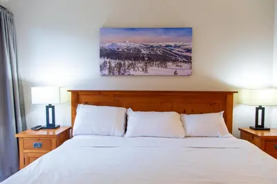 a bedroom with a bed with snow covered mountains at 1BR next to slopes on Blackcomb w pool & hot tub in Whistler