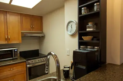 a kitchen with a sink and a clock on the wall at 1BR next to slopes on Blackcomb w pool & hot tub in Whistler