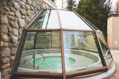 a glass enclosure with a hot tub inside of it at 1BR next to slopes on Blackcomb w pool & hot tub in Whistler